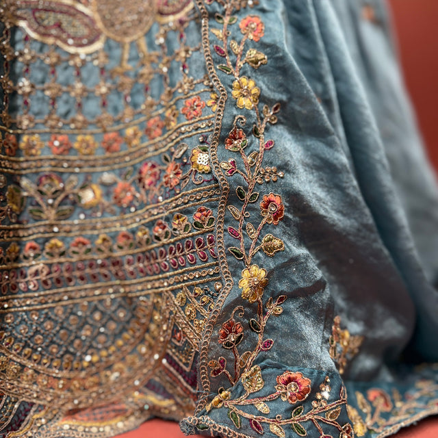 Teal blue silk lehenga with gold zari and multicolor peacock embroidery border