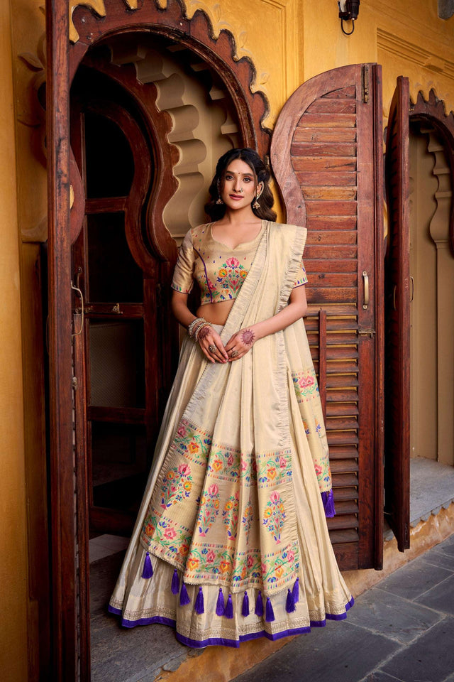Cream lehenga choli with multicolor floral print, matching dupatta, blue tassel hem