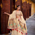 Cream lehenga choli with multicolor embroidered border and red tassel dupatta