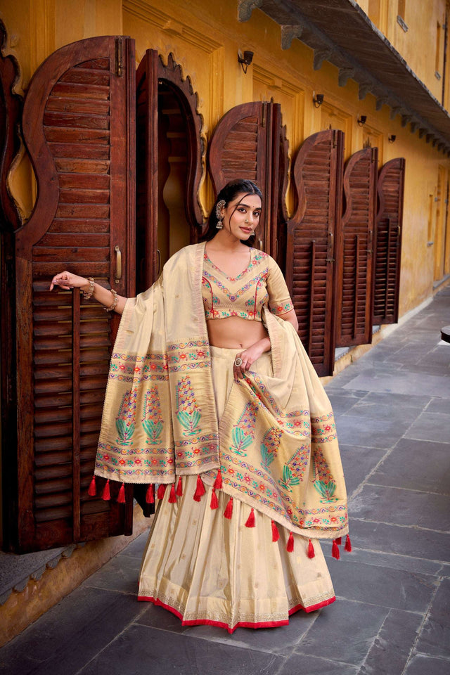 Cream lehenga choli with multicolor embroidered border and red tassel dupatta