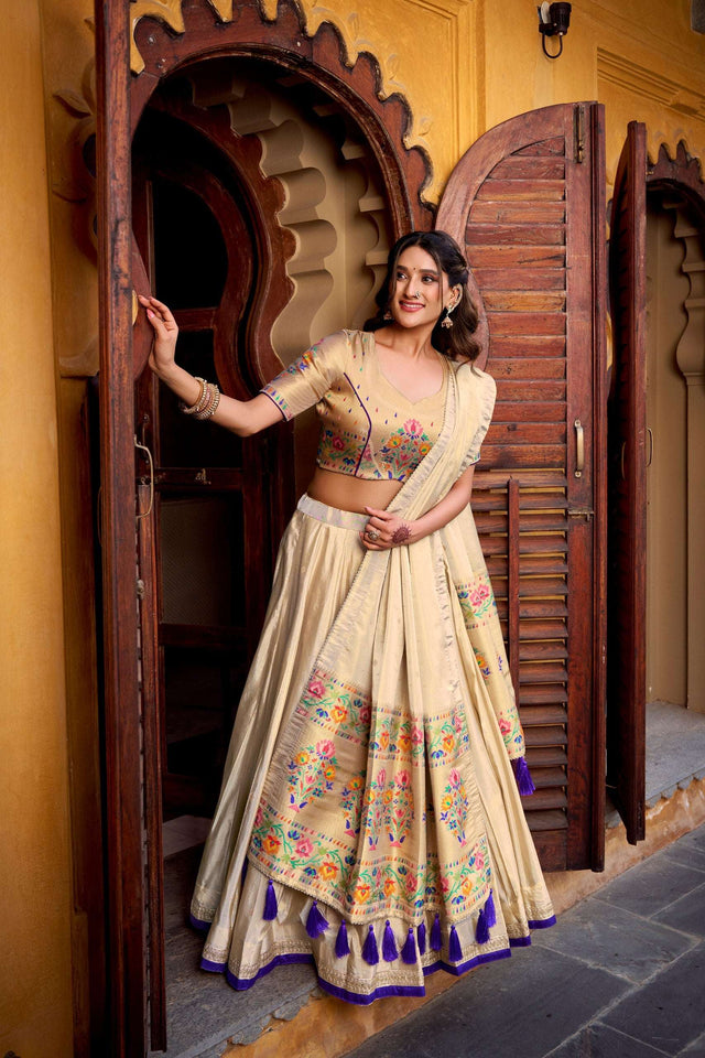 Flared cream lehenga skirt with multicolor floral panel and blue tassel border, dupatta