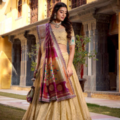 Gold lehenga choli with wide purple border, multicolor zari accents, and flowing drape