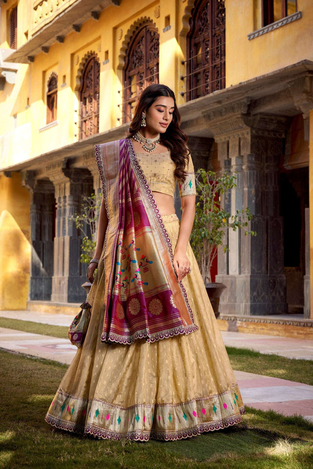 Gold lehenga choli with wide purple border, multicolor zari accents, and flowing drape