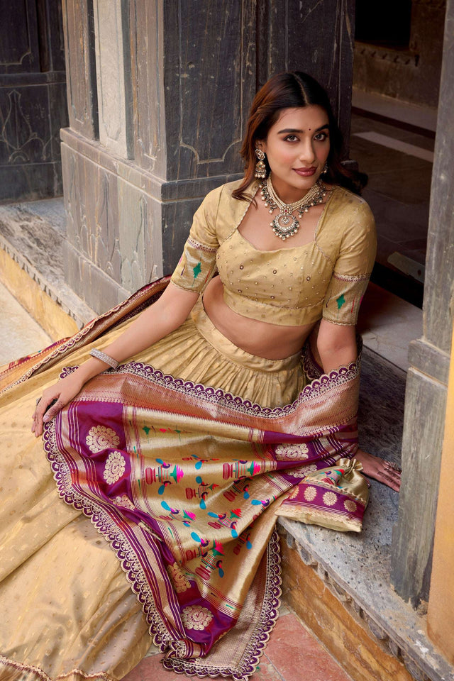 Gold lehenga with embellished blouse and draped purple dupatta, multicolor thread motifs