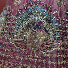 Close-up of dusty rose lehenga bodice with peacock fan motif and ornate zari embroidery