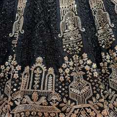 Close-up of black net lehenga: antique gold jharokha arches, flowering urns and vine sprays