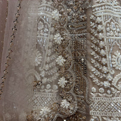 Close-up of ivory net lehenga: antique gold cutdana, pearl flowers and sequin drops