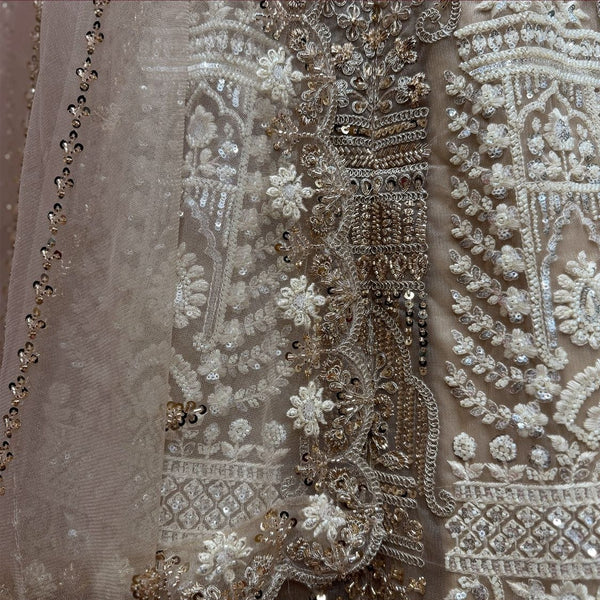 Close-up of ivory net lehenga: antique gold cutdana, pearl flowers and sequin drops