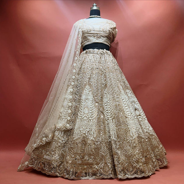Ivory net lehenga with antique gold cutdana and pearl embroidery, scalloped hem and net dupatta