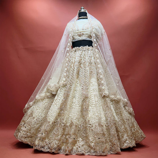 Off white net lehenga with pearl and golden cutdana embroidery, scalloped hem and sheer net dupatta