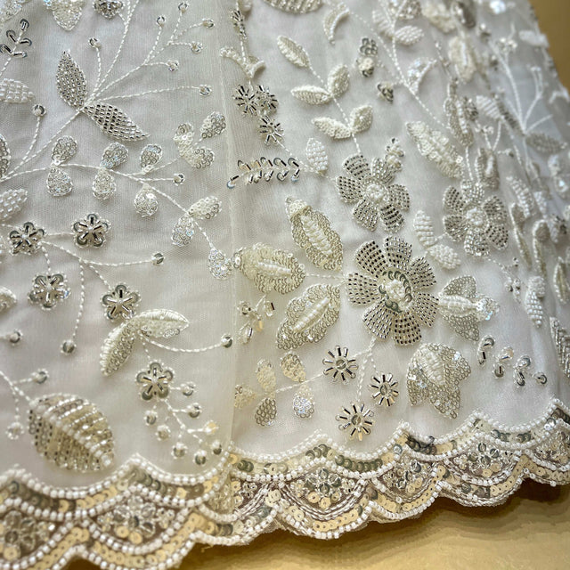 Off-white lehenga fabric with beaded and pearl floral embroidery and border trim
