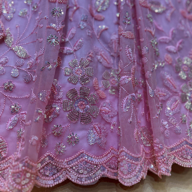 Pink-toned lehenga fabric with bead and pearl floral motifs and scalloped border.