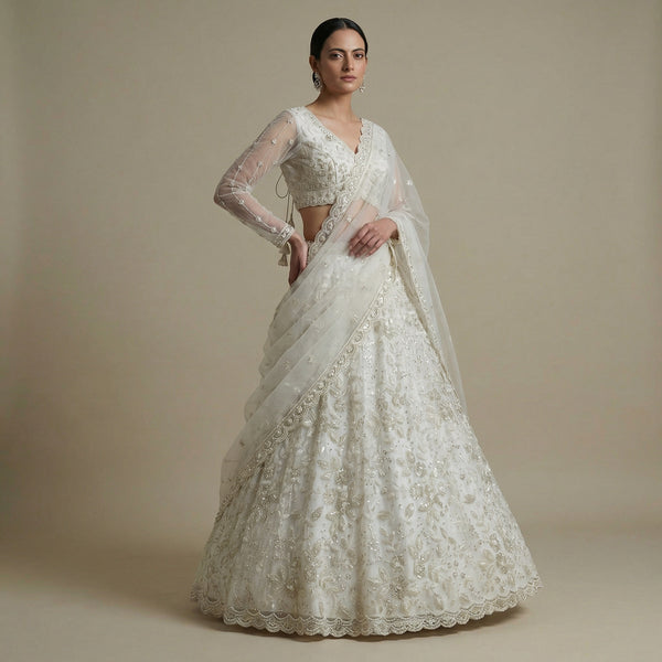 Off-white designer lehenga with embroidered bodice and flared skirt, beadwork details