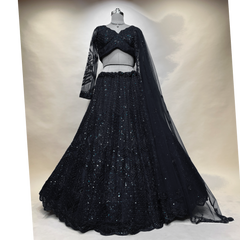 Black designer lehenga on mannequin: sequined V-neck blouse, full flared skirt, sheer cape