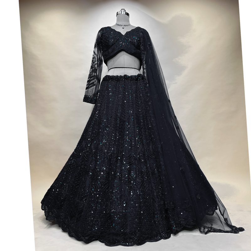 Black designer lehenga on mannequin: sequined V-neck blouse, full flared skirt, sheer cape