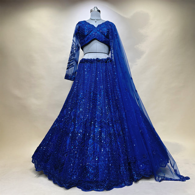 Blue embellished lehenga on mannequin with long-sleeve blouse and flowing flared skirt