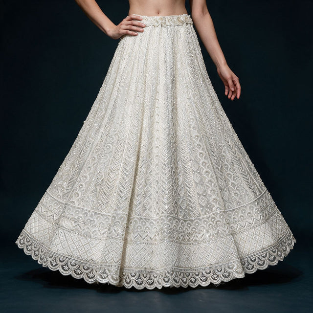 Off white net lehenga skirt with beaded chevron, scallop and diamond bands and fabric roses at the waist