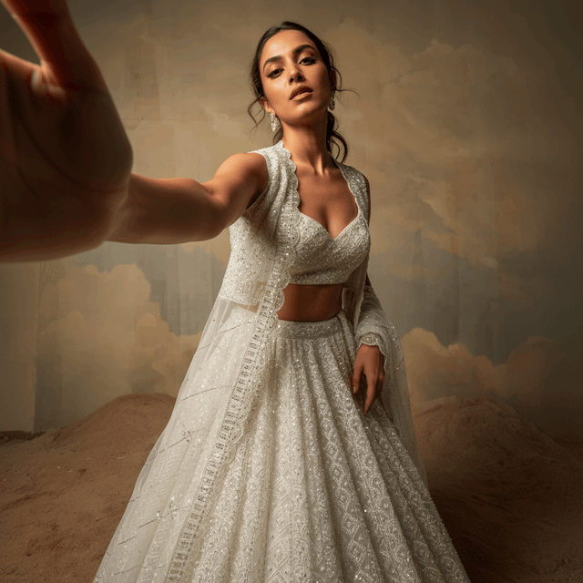 Off-white beaded crop top and lehenga with sheer drape, side view