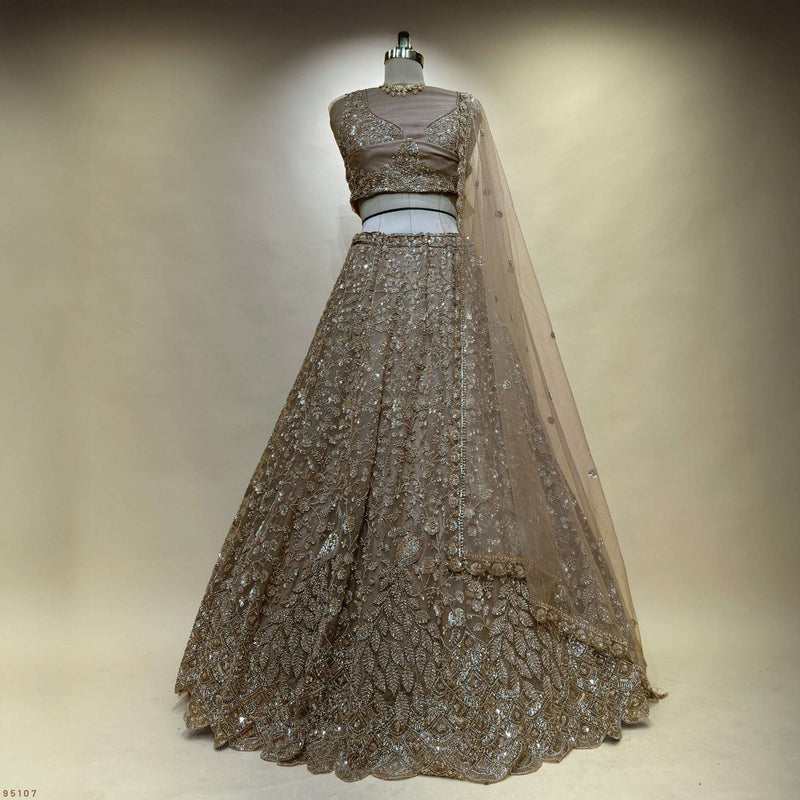 Champagne gold lehenga choli set on mannequin with sheer dupatta and embellished bodice