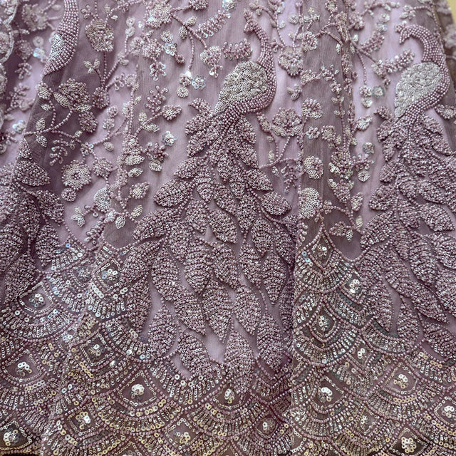 Lilac pink embroidered fabric with dense floral and beadwork motifs