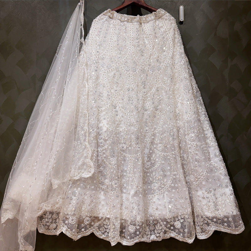 White embellished lehenga with lace overlay and matching sheer dupatta
