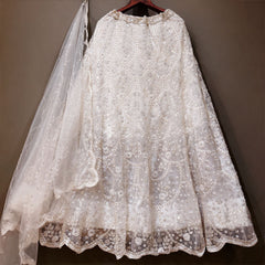White beaded net lehenga skirt with scalloped hem and sequin net dupatta on hanger