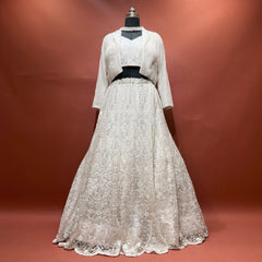 White beaded net lehenga set with blouse and jacket on mannequin