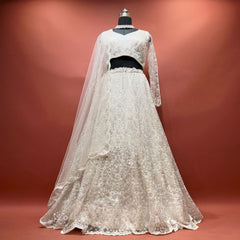 White beaded net lehenga set with full-sleeve blouse and dupatta on mannequin