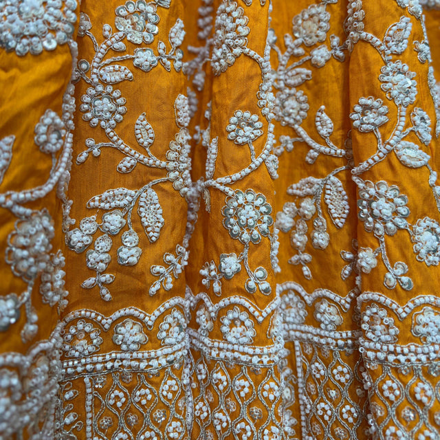 Orange fabric with dense silver floral and border embroidery