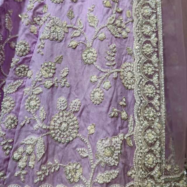 Lavender fabric swatch with gold-toned floral embroidery and beadwork