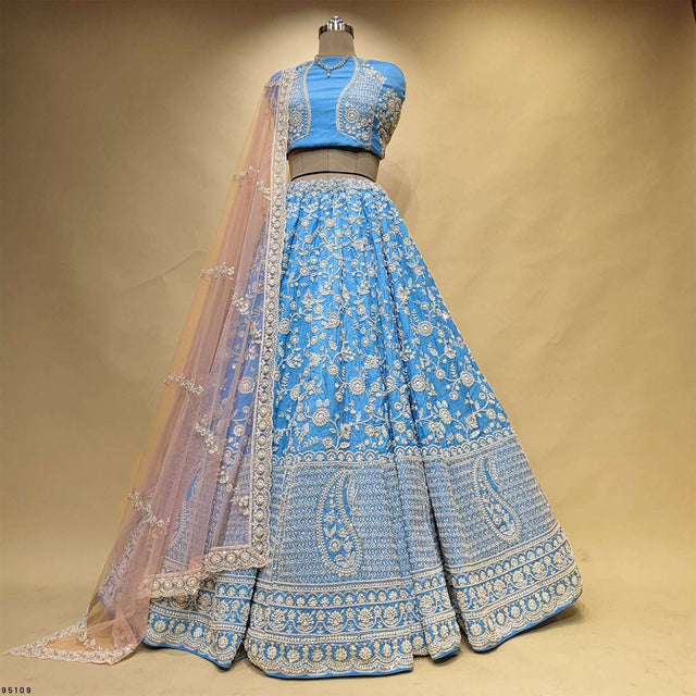 Blue lehenga with matching belt, long-sleeve blouse, and draped sheer dupatta detail