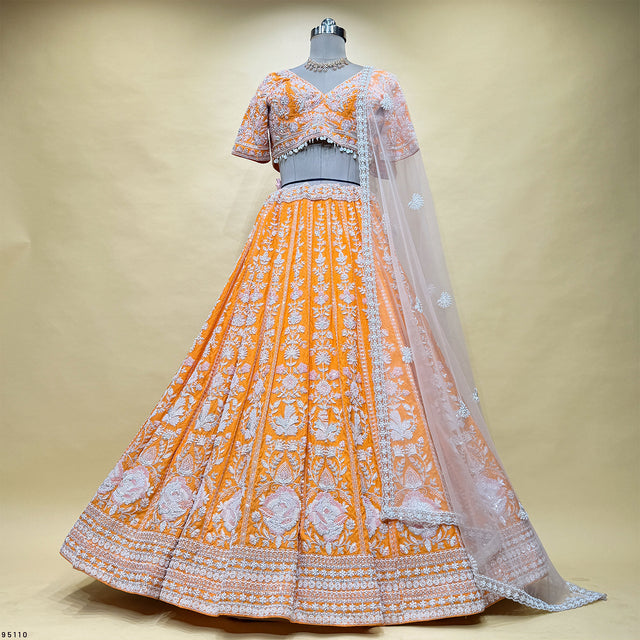 Orange and silver lehenga with short-sleeve blouse, full skirt, and sheer dupatta