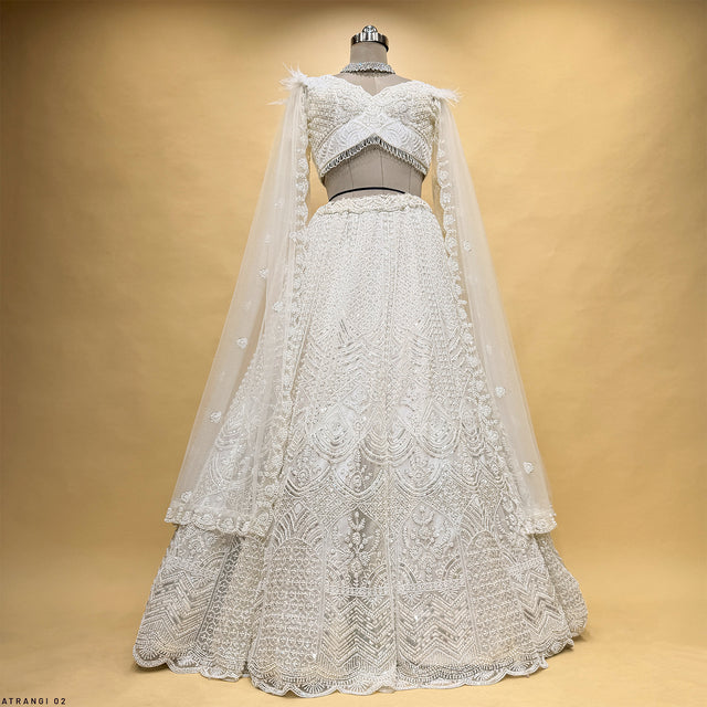 Off-white net lehenga on mannequin with cape overlay and textured skirt