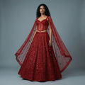 Deep red embellished lehenga set with corset blouse and sheer star dupatta