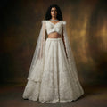 Pearl white embroidered lehenga with sheer cape dupatta and beaded crop top