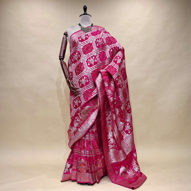 Rani pink satin silk saree with zari-patterned pallu and ornate border, draped