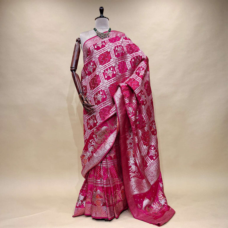 Rani pink satin silk saree with zari-patterned pallu and ornate border, draped
