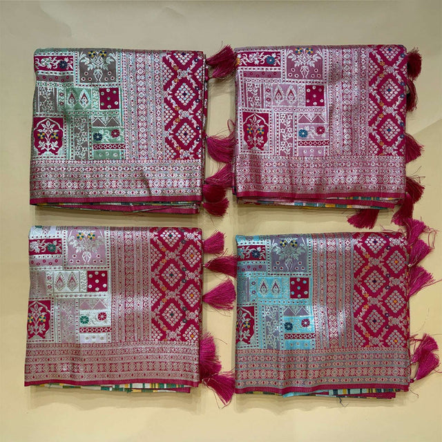Set of folded patola-style silk sarees with teal and pink geometric prints, magenta borders