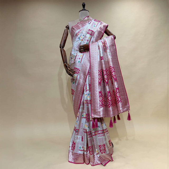 Patola-style silk saree with pink/off-white geometric motifs and magenta border tassels