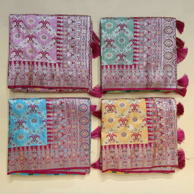 Folded patola-style silk saree swatches in teal, green, pink, and yellow with borders