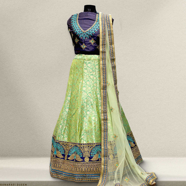Green Banarasi silk lehenga with blue V-neck blouse and gold-patterned dupatta