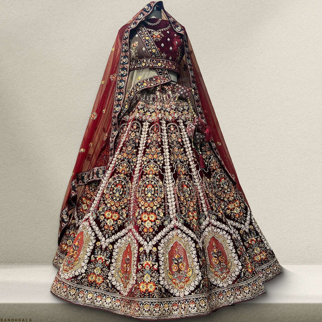 Embroidered bridal lehenga with dark maroon skirt, gold trim, and sheer dupatta