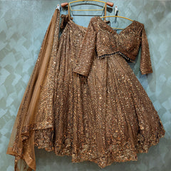 Brown-gold sequin lehenga set on hangers with blouse and sheer dupatta