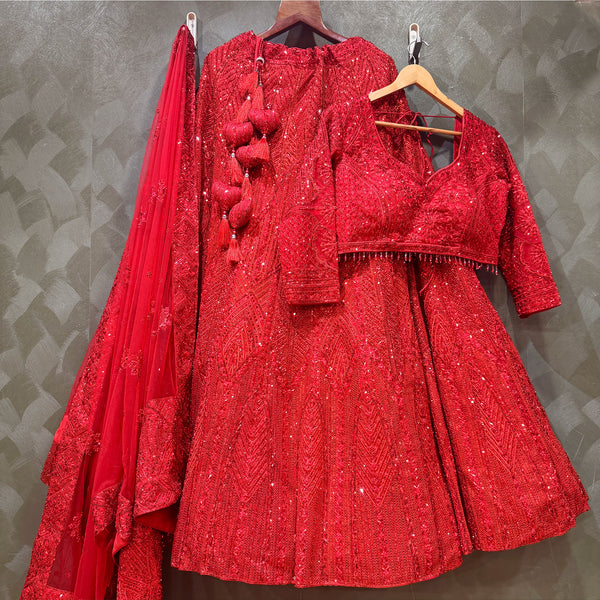 Red sequin lehenga set on hangers: blouse, skirt, and sheer dupatta
