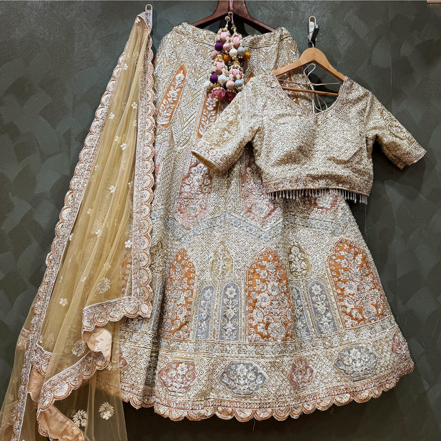 Ivory lehenga set with fitted blouse, ornate embroidered bands, and sheer embellished dupatta