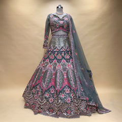 Embroidered lehenga on mannequin with floral motifs, gray-blue base, pink and silver trim