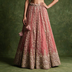 Close-up of the dusty rose pink lehenga skirt with gold cutdana and pearl vines, a deep embroidered border and pink tassel latkans at the waist