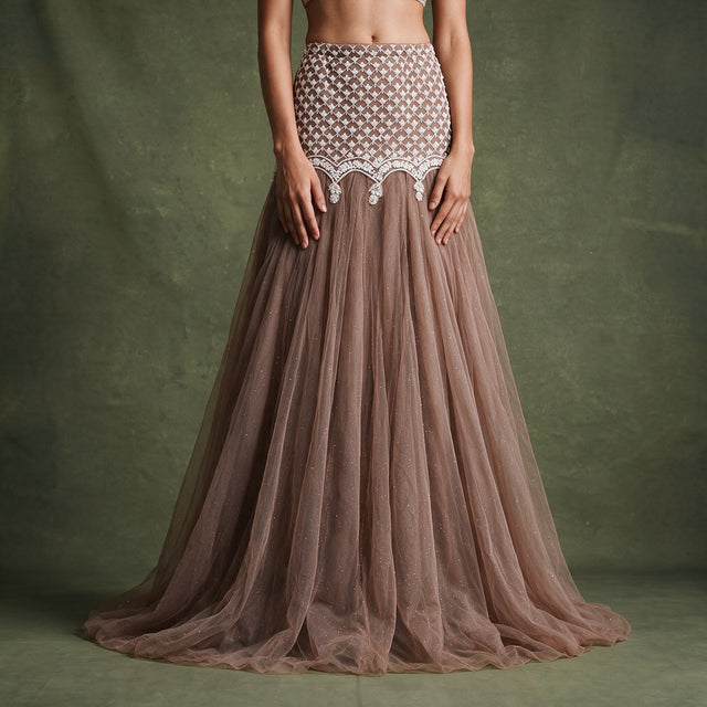 Close-up of the mocha brown net fish cut skirt with its ivory beaded lattice yoke, scalloped edge at the hip and long flared net hem