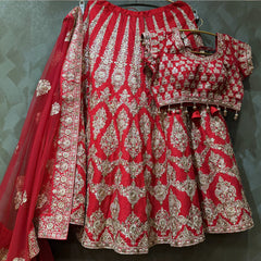 Red lehenga skirt and blouse set with heavy gold zari motifs, decorative border hem