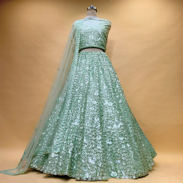 Pista green sequin net lehenga set with blouse and dupatta on mannequin